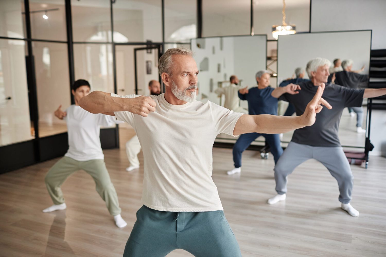 A group practising tai chi in a mirrored studio